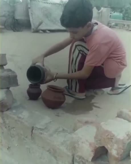Vansh pouring water into clay pots